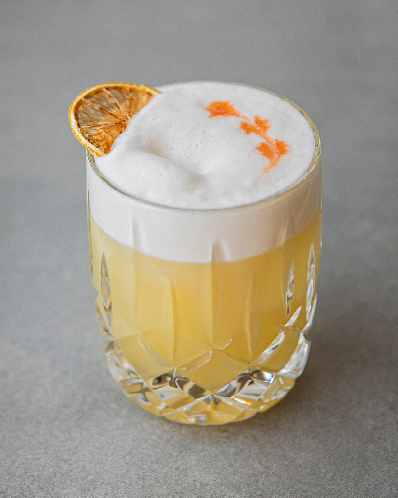 Cocktail Godfather Sour garni d'une rondelle d'orange déshydratée