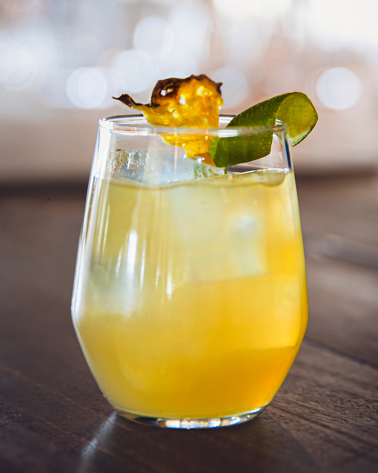 Cocktail Tropical Swing garni d'une tranche d'ananas et d'un zeste de lime